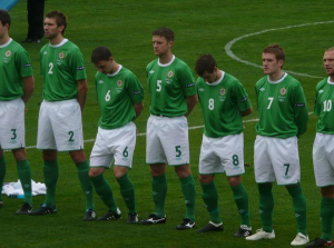 Chris Baird and Niall McGinn are seen bowing their heads during a rendition of 